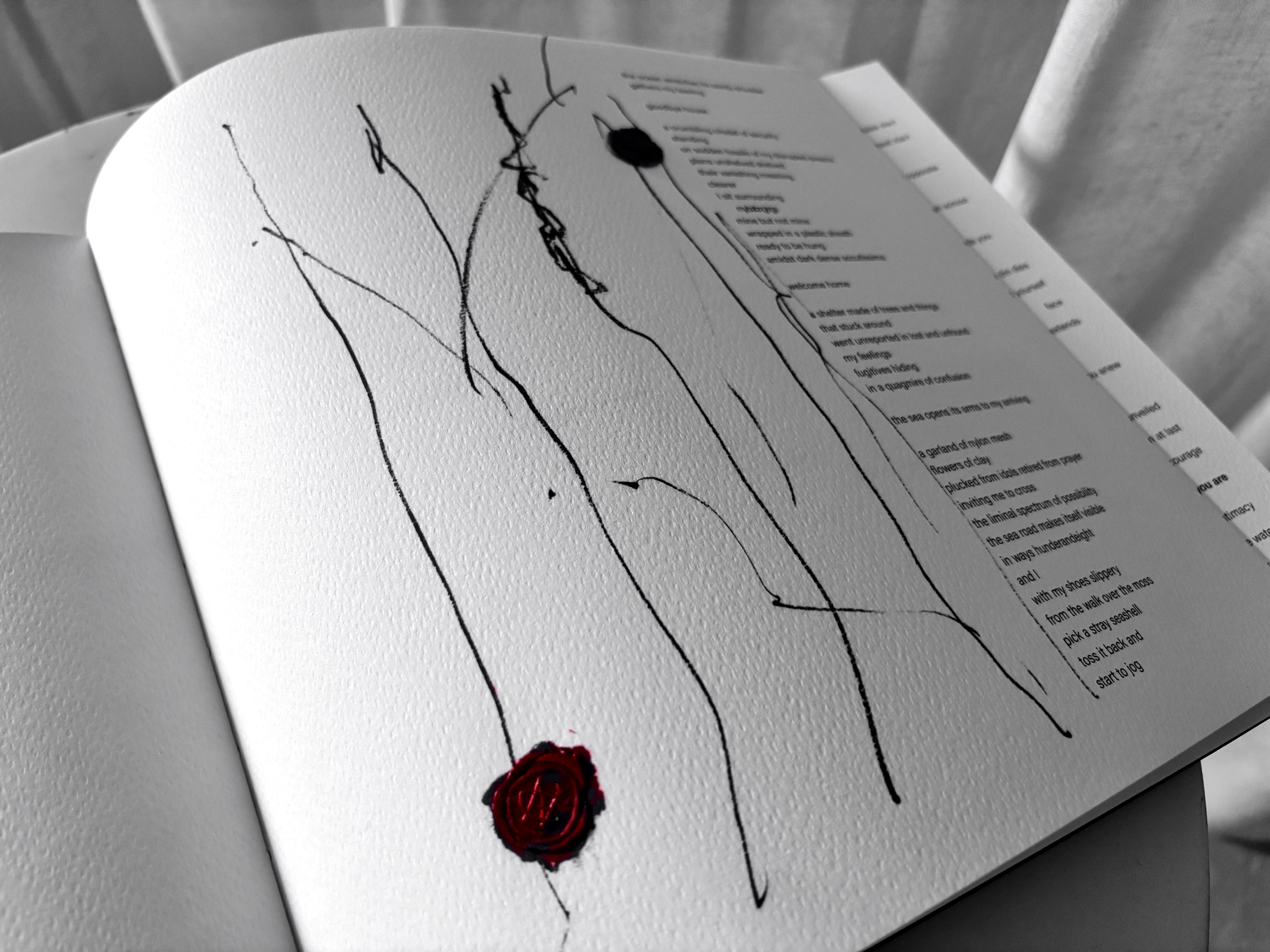 A page of falling ink lines with a wax seal pressed at its foot, the book open on a chair